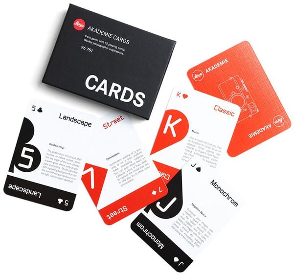A set of Leica Akademie playing cards featuring photography tips and styles, such as Landscape, Street, Classic, and Monochrom, displayed next to a black box labeled “CARDS.”.