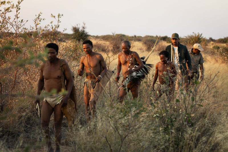 A group of men walking through a field.