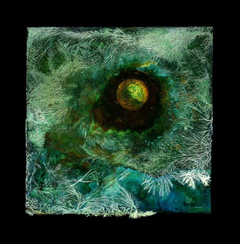 Abstract artwork with a textured green and teal background, featuring a dark central area surrounding a glowing yellow-green circular shape, with white, frost-like patterns radiating around the edges.