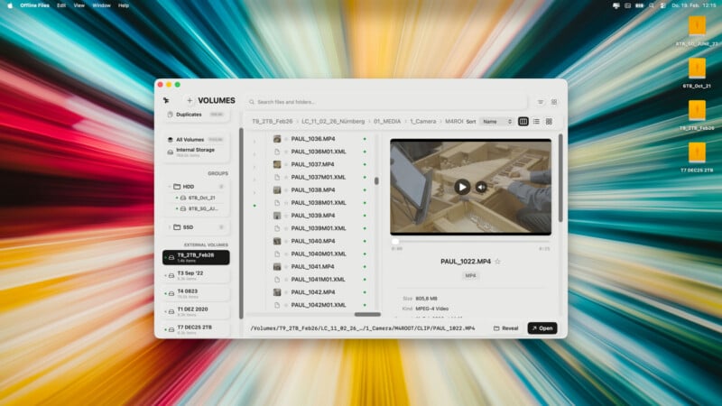 A computer screen displays a file management application showing folders and video files, with a preview of a video featuring a person's hands at a desk. The desktop background has a colorful, radial burst pattern. Four orange folders are on the right.
