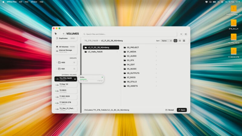 A computer screen shows a file manager window with external drives listed on the left and folders on the right. The background displays a colorful, radial burst pattern. Several folders and files are visible on the desktop.