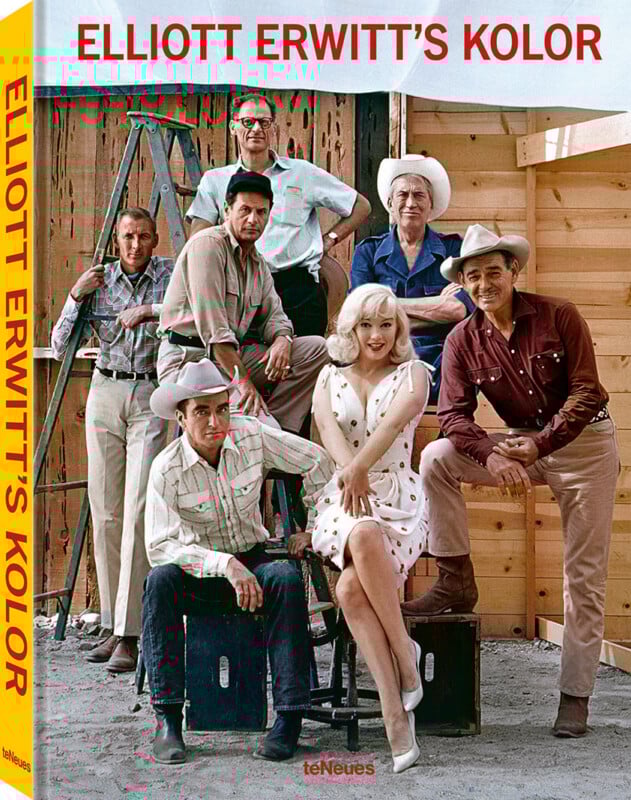 Seven people, including a woman in a white dress and six men in cowboy attire, pose in front of a wooden building under construction. The cover reads "ELLIOTT ERWITT’S KOLOR.