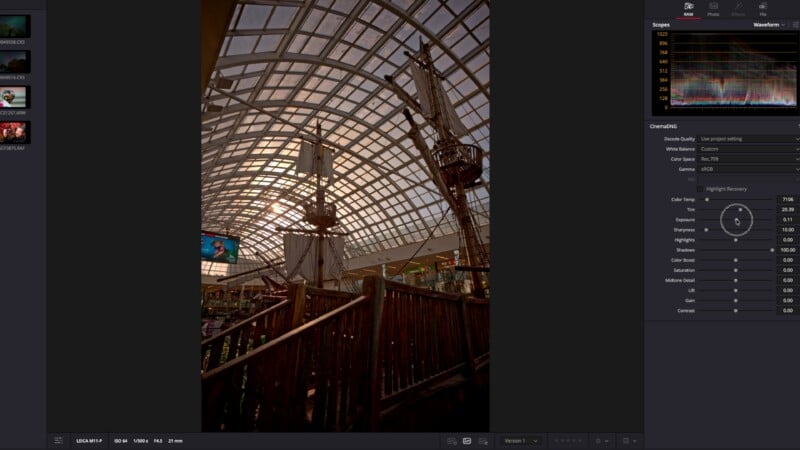 A large indoor pirate ship display stands beneath a high, glass-paneled dome. Wooden railings and ship masts are visible, with sunlight filtering through the curved roof structure.