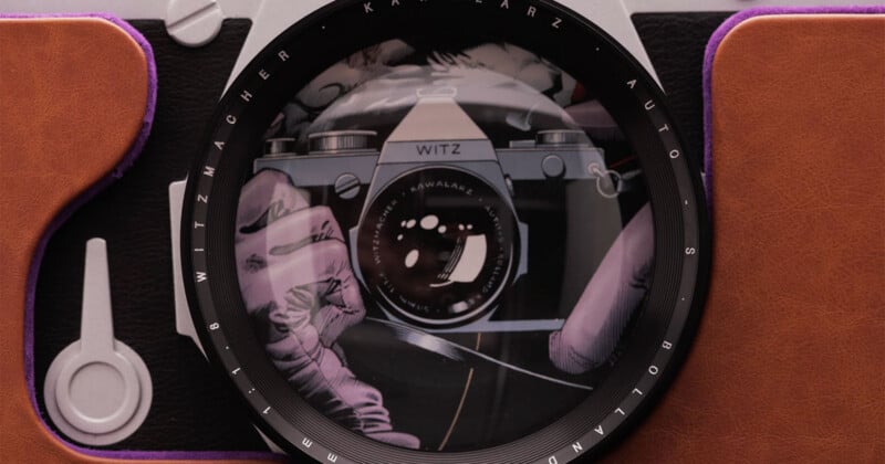 Close-up of a vintage camera lens reflecting an illustration of gloved hands holding another camera. The camera body is brown with black and silver details, and the lens has white lettering around its rim.