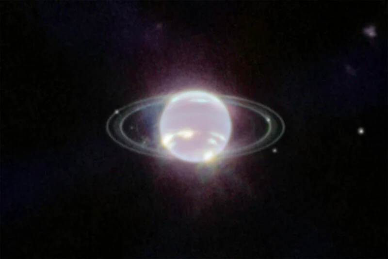 A bright, bluish planet with faint rings and several small moons is seen against a dark space background.