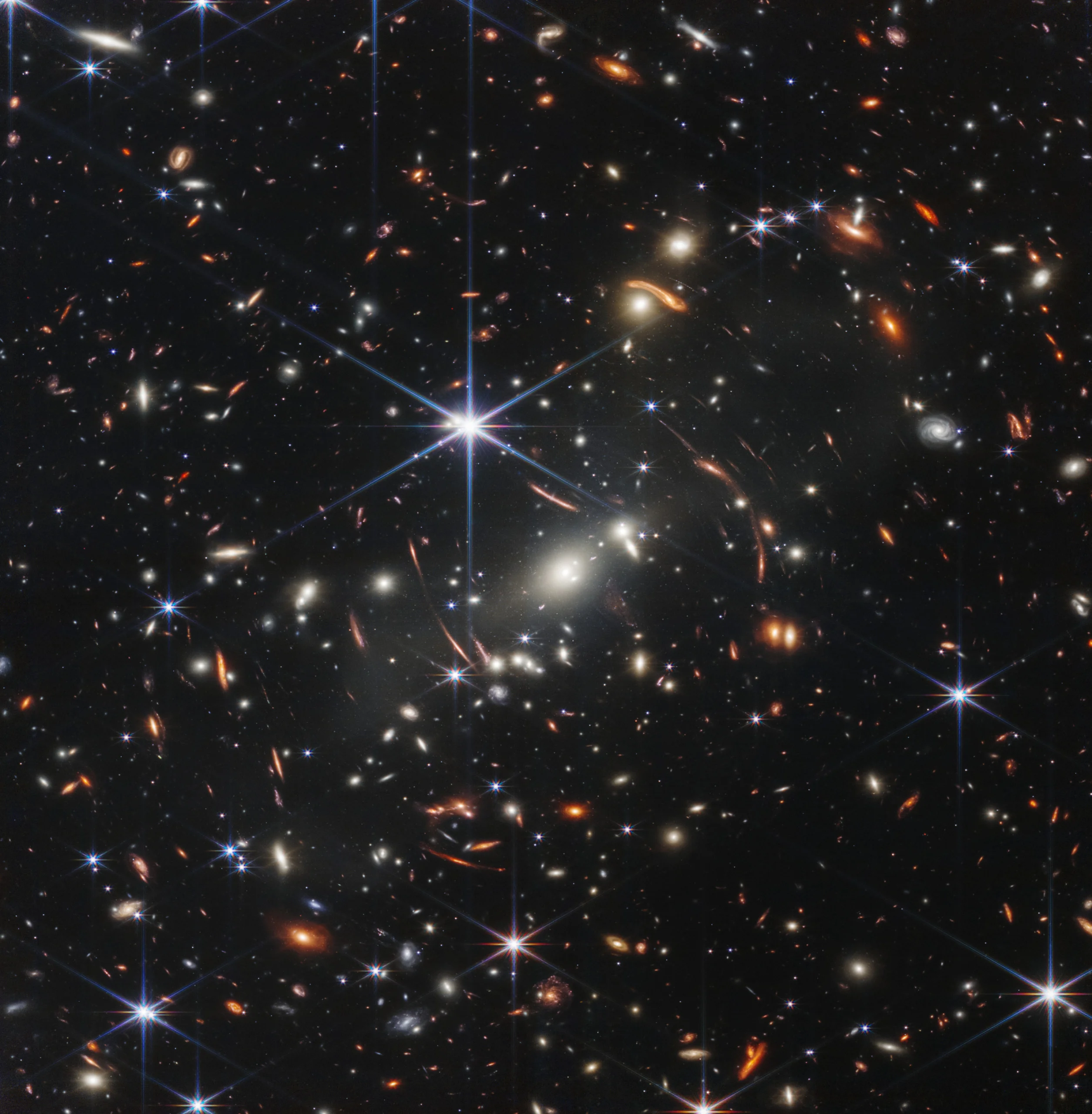 deep space photo showing hundreds of small individual galaxies and stars with spiral structures