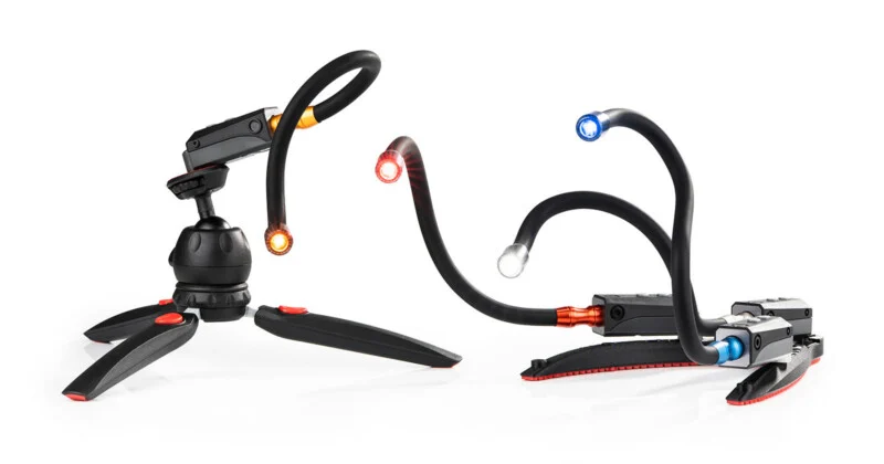 Two flexible, multi-armed LED task lights stand on a white surface, one mounted on a tripod base and the other on a flat base.