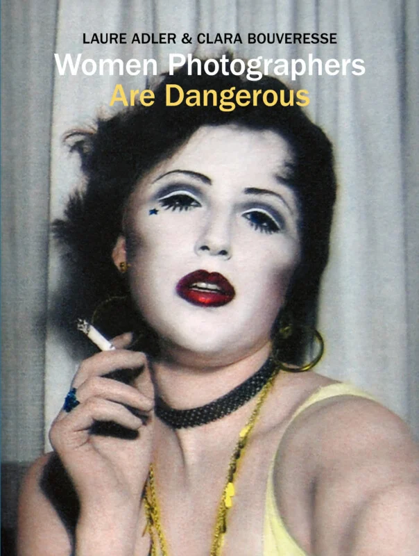 The book cover for "Women Photographers Are Dangerous" by Laure Adler and Clara Bouveresse features a portrait of a woman with heavy makeup, a star on her cheek, and a cigarette in her hand.