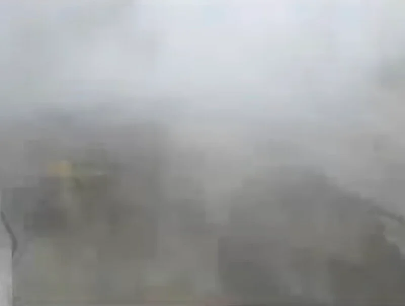 A view from a high vantage point looking down at buildings partially obscured by thick, heavy fog.