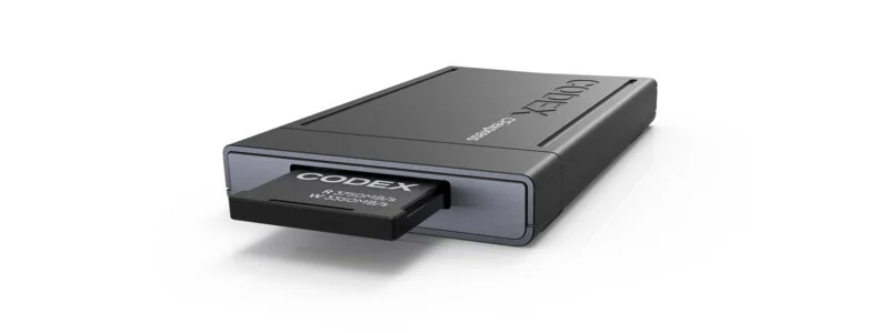 A Codex CFexpress memory card is partially inserted into a gray Codex card reader on a white background.
