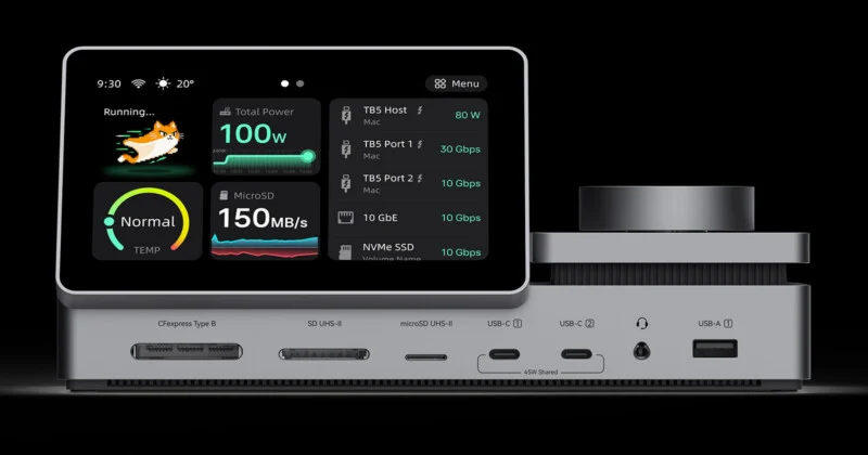A silver docking station with a built-in touchscreen display showing system performance metrics, featuring various ports including card readers, USB-C, and USB-A.