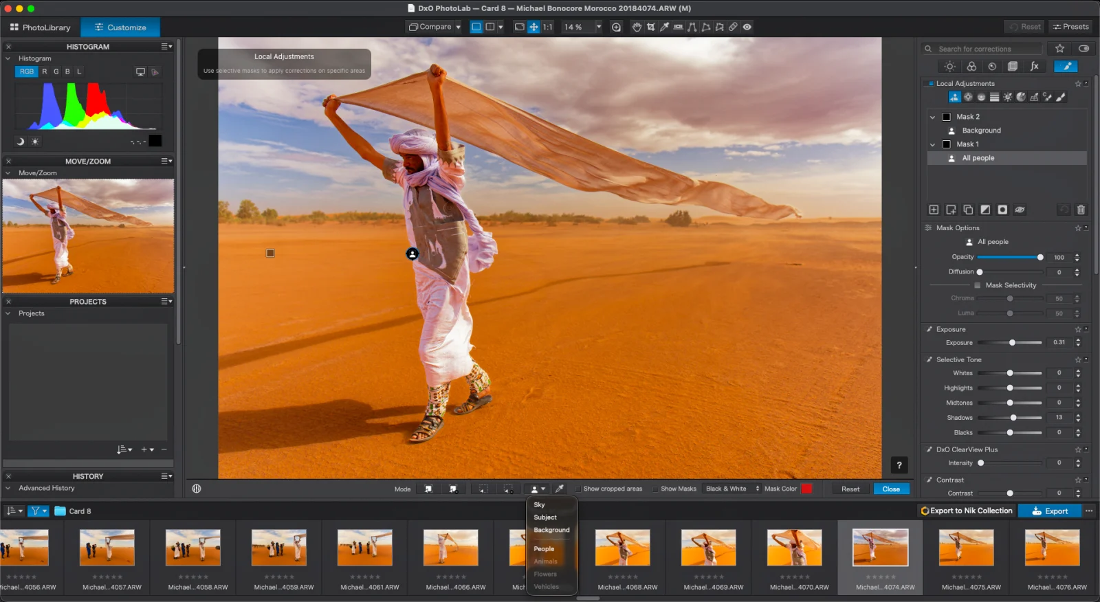 A man in traditional clothing walks across a desert landscape while holding a large, flowing fabric above his head, displayed within the DxO PhotoLab software interface.