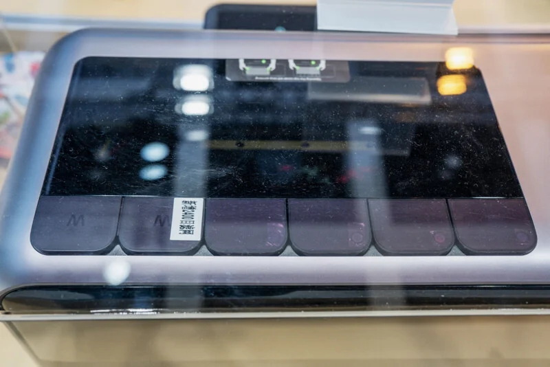 A close-up view of a device with a row of six rectangular camera lenses, one of which has a small white sticker with Chinese text.