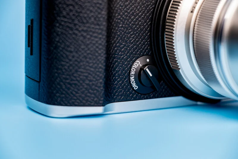 A close-up of a camera body featuring a physical switch labeled