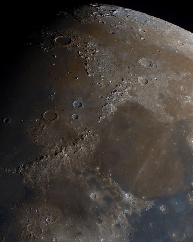A high-resolution, color-enhanced view of the Moon's surface showing craters, lunar maria, and rugged terrain.