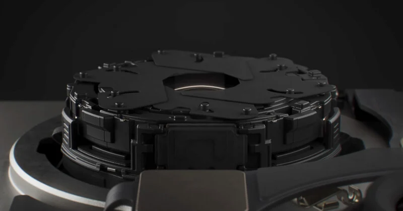 A close-up view of a mechanical camera aperture mechanism with overlapping black blades centered within a circular housing.