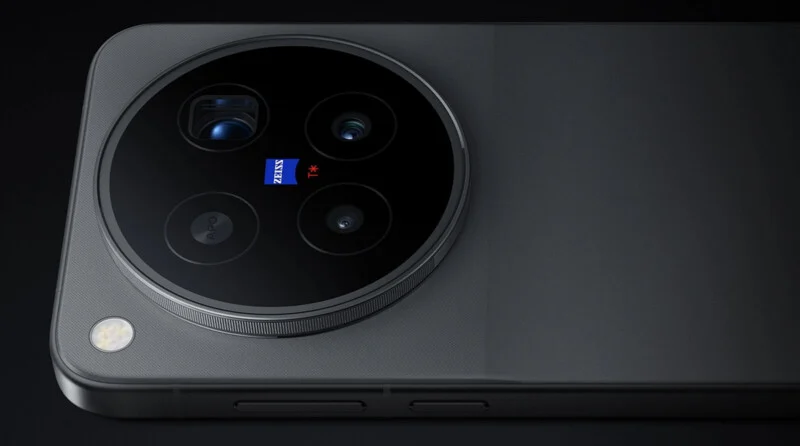 A close-up of a dark gray smartphone back featuring a large circular camera module with four lenses, a ZEISS logo, and a flash.
