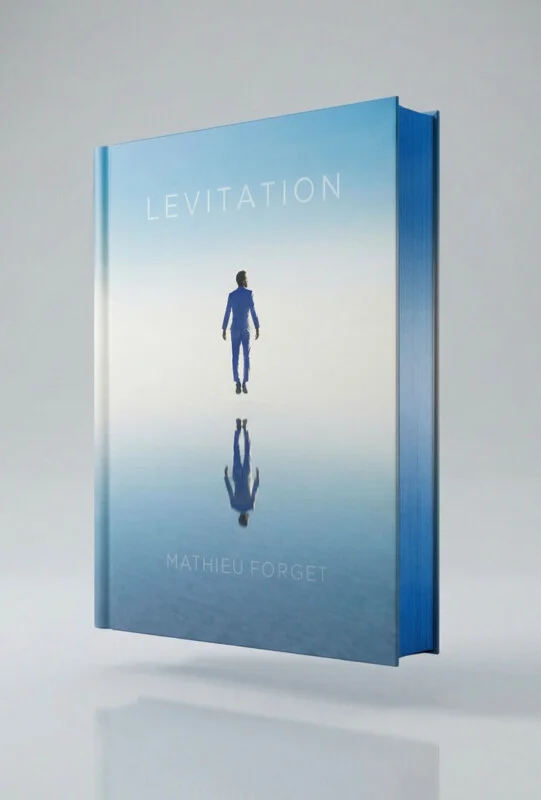 A book titled "Levitation" by Mathieu Forget stands upright, featuring a cover image of a man in a blue suit floating above a reflective surface against a light blue sky.