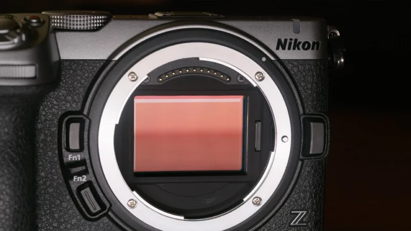 A close-up view of a Nikon Z-mount camera body with the lens removed, showing the exposed image sensor and electronic contact pins.