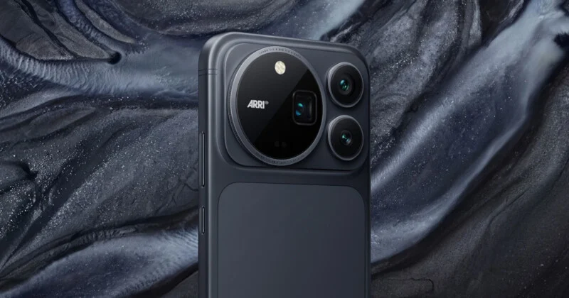 A close-up of a dark gray smartphone back featuring a large, circular camera module with three lenses and the text "ARRI" printed on it, set against a textured, abstract dark background.