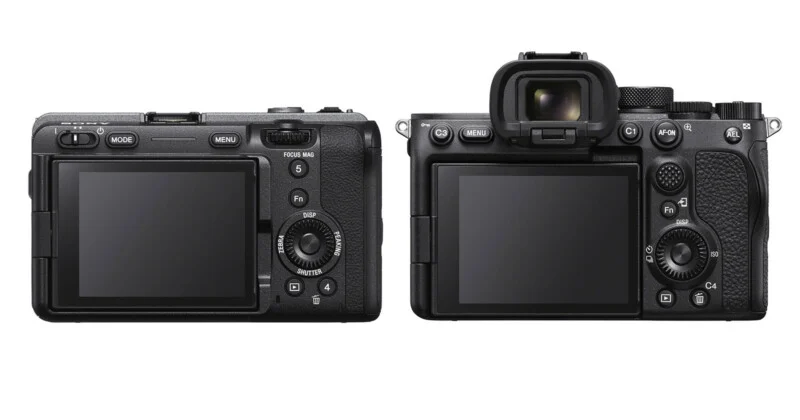 Two black digital cameras shown from the rear, with the one on the left lacking a viewfinder and the one on the right featuring an electronic viewfinder.