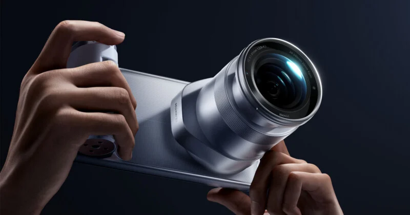 A pair of hands holds a silver smartphone with a large, protruding camera lens attachment on the back, featuring the text "HUAWEI" and "XMAGE" printed on the device.
