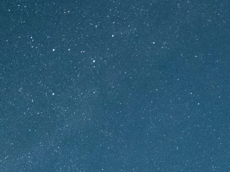 A dense field of stars scattered across a dark blue night sky.